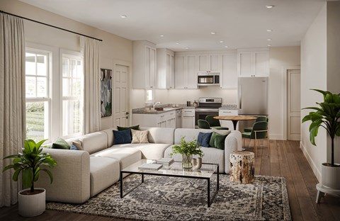 a living room with a couch and a table in front of a kitchen